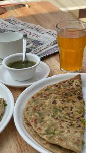 MiānīTSR Inn By Xplore Mantra Hotel and Cafe, Nagtibba的桌子上摆着一盘食物和一杯啤酒