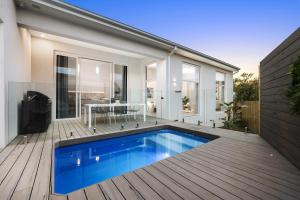 a house with a swimming pool on a wooden deck at Bella Villa in Safety Beach