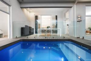 a large swimming pool in a living room with a table at Bella Villa in Safety Beach +23 photos