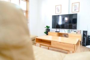 a living room with a coffee table and a flat screen tv at Banrao Pool Villa Khaoyai บ้านเราพูลวิลล่าเขาใหญ่ in Ban Tha Maprang