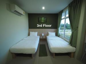 two beds in a room with a floor at Sleepwell@naiyang in Nai Yang Beach