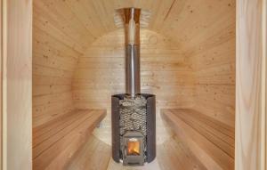 a wood burning stove in a wooden cabin at Amazing Home In Fårevejle With Sauna in Fårevejle +30 photos