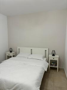 a white bed with two night stands next to it at CLAS Studio in Sibiu