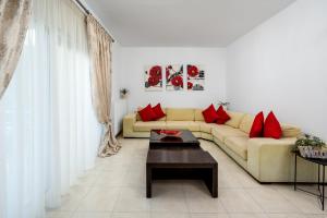 ein Wohnzimmer mit einem Sofa und roten Kissen in der Unterkunft Amazing Summer Villa in Kolymbia
