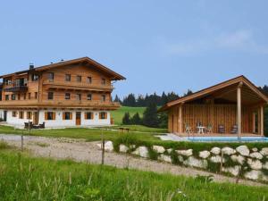 a large wooden house with a pool in front of it at Winklerhof Ebbs in Ebbs