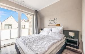 Un dormitorio con una cama grande y una ventana grande. en Roggen-Koje, en Büsum