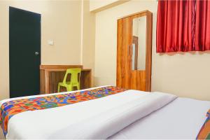 a bedroom with a bed and a wooden door at FabHotel New Falcon Inn - Nr Balewadi stadium in Pune