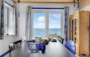 una sala da pranzo con tavolo e vista sull'oceano di Three-Bedroom Holiday Home In Bagenkop a Bagenkop