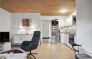 uma cozinha com armários brancos e uma cadeira preta em Cozy Apartment In Middelfart With Wifi em Middelfart