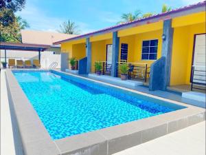 a swimming pool in front of a house at Ziella De Villa in Pantai Cenang