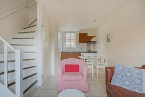 a living room with a pink chair and a kitchen at Duinstraat 10 in Domburg