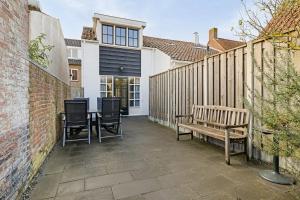 Un patio con dos sillas y una mesa y un banco. en Duinstraat 10, en Domburg