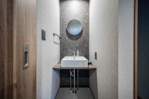 a bathroom with a sink and a mirror at THE CITYSCAPE in Kita-sanjō