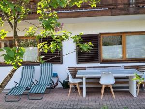 a picnic table and chairs in front of a house at 80 m2, für bis 6 Personen mit tollem Skigebiet, zentral und doch ruhig in Waidring +22 photos