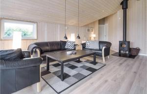 Una sala de estar con muebles de cuero y una estufa de leña. en Four-Bedroom Holiday Home In Hemmet, en Hemmet