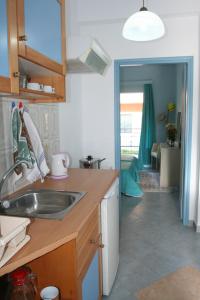 a kitchen with a sink and a living room at Roda Pearl Resort in Roda +59 photos