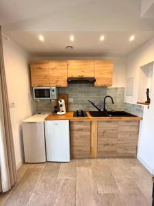 una cucina con elettrodomestici bianchi e armadietti in legno di Superbe studio neuf vue mer a Monticello Altre 9 foto