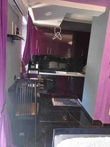 cocina con armarios morados y encimera negra en Guest House CELLOSIA, en Përmet 8 fotos más