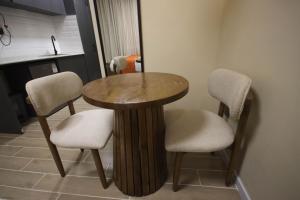 a wooden table and two chairs in a room at Pristine Homes Studio Apartment - Mombasa Road in Nairobi +3 photos