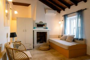 a small room with a bed and a fireplace at Nissaki Olive Press Villas in Nisakion