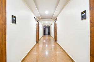 un corridoio con pareti bianche e pavimento piastrellato di FabHotel Prime Srishoin - Nr TCS Deccan Park, Hitech City a Hyderabad