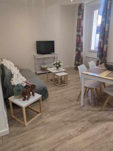 Néoulesにあるappartement dans le villageのリビングルーム(ソファ、テーブル、テレビ付)