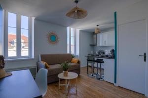 a living room with a couch and a table at La Girelle -4 pers- Balcon- parking gratuit in Bourg-en-Bresse