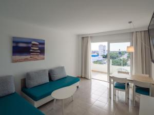 a living room with a couch and a dining table at Apartamentos La Santa Maria in Cala Millor