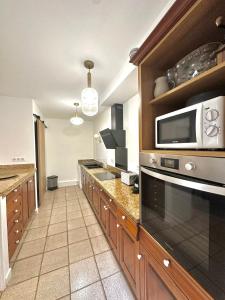 una cucina con forno a microonde e piano di lavoro di Charmante maison de village ad Argelès-sur-Mer