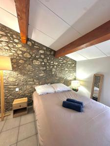 una camera da letto con un letto grande con un muro di pietra di Charmante maison de village ad Argelès-sur-Mer