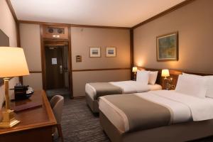 a hotel room with two beds and a desk at Grand Hotel Bucharest in Bucharest