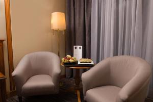 two chairs and a table with a bowl of fruit at Grand Hotel Bucharest in Bucharest