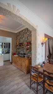 a large kitchen with a table and a brick wall at Le Petit Chateau in Saint-Michel