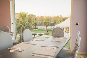 a table with white chairs and a large window at Hotel Park in Sottomarina