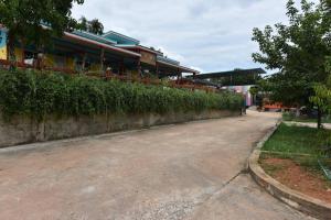 a street in front of a building with a fence at Campchamao in Ban Ra-ok +3 photos