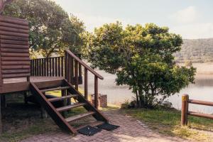 a wooden staircase next to a body of water at Riverside Self Catering Cabin in Wilderness