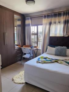 a bedroom with a bed and a table and a desk at Alimop Bed and Breakfast in Midrand
