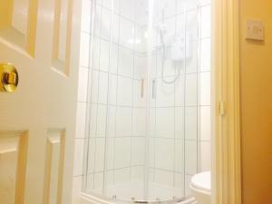 a shower in a bathroom with a toilet at Southend Inn Hotel - Close to Beach, Train Station & Southend Airport in Southend-on-Sea