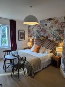 a bedroom with a large bed and a table with chairs at The Duke Hotel in Hilmarton