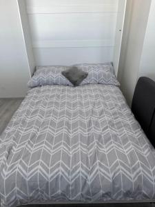 Bett mit grauer Bettdecke in einem Zimmer in der Unterkunft Apartman Komenského-Centrum in Banská Bystrica