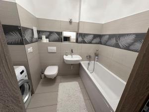 ein Badezimmer mit Waschbecken, Badewanne und Toilette in der Unterkunft Apartman Komenského-Centrum in Banská Bystrica + 7 Fotos