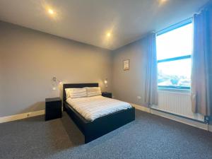 a bedroom with a bed and a large window at 1 bed Apt close to Leeds Arena Sleeps up to 4 people F1 in Leeds