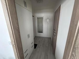 einen leeren Flur mit Tür und Spiegel in der Unterkunft Apartman Komenského-Centrum in Banská Bystrica
