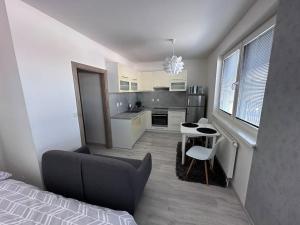 a bedroom with a bed and a table and a kitchen at Apartman Komenského-Centrum in Banská Bystrica