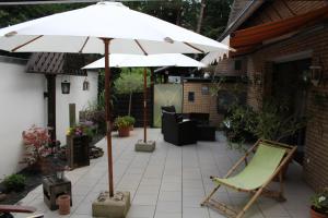 einen Regenschirm und einen Stuhl auf einer Terrasse in der Unterkunft Dachstudio Sternenblick in Bad Münstereifel