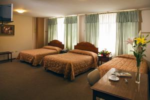 En eller flere senger på et rom på Hotel Podocarpus