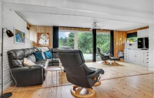 a living room with a leather couch and chairs at Lovely Home In Gørlev With Kitchen in Gørlev