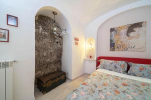 a bedroom with a red bed and a stone wall at Torre del Califfo Amalfi Relais in Amalfi