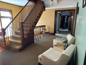 a living room with a staircase and a couch and chairs at Summer Street Guest House in Buffalo