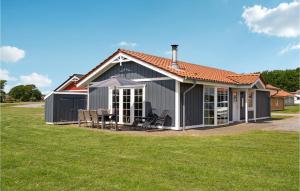 a gray house with a table and chairs in a yard at Nice Home In Gråsten With Sauna in Gråsten +23 photos